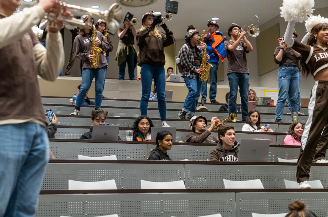 Marching 97 band members on tables in a lecture hall