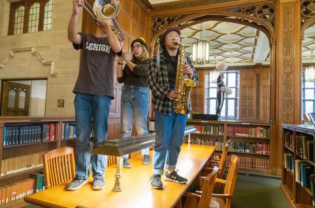 Marching 97 band members on tables in Linderman Library