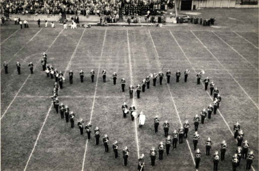 Players and students forming a heart on the field