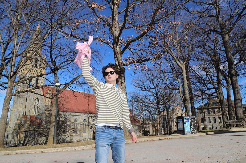 Student reaches to catch a shirt in the air