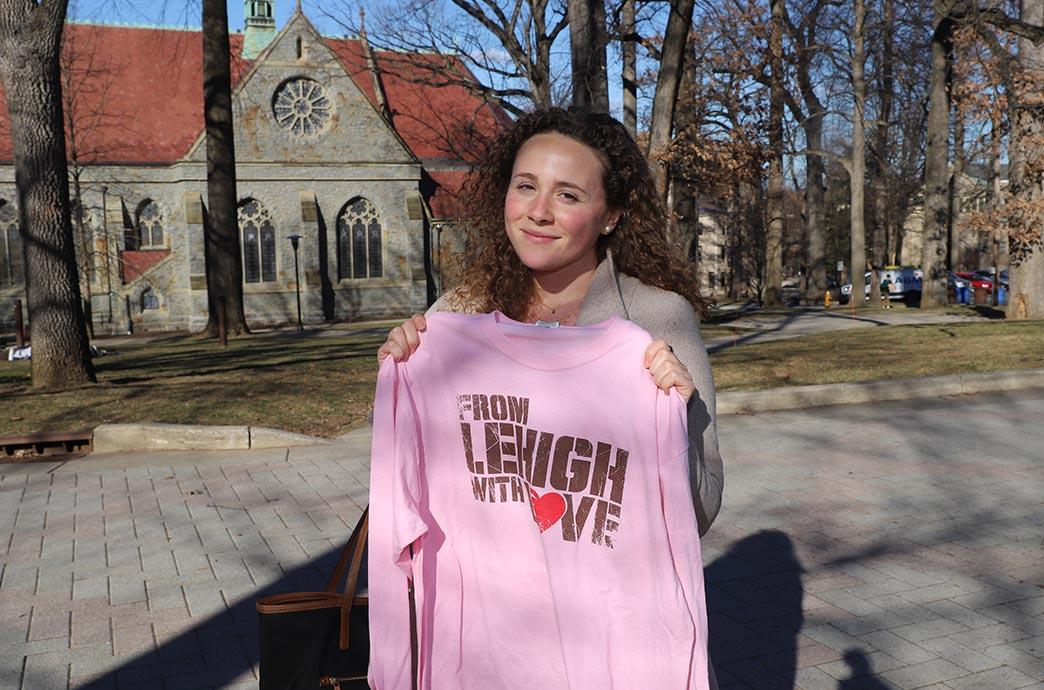 Woman smiles slightly while holding shirt