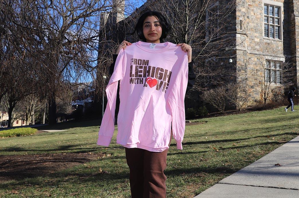 Student in headphones holds up shirt