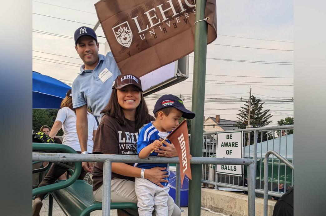 A mother and son sitting under a brown Lehigh University banner