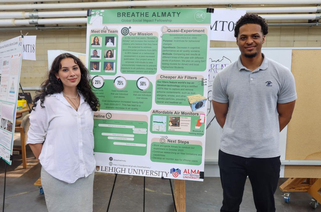 Students Kaliana Odonnell and Allen Wilson standing next to a poster about their project