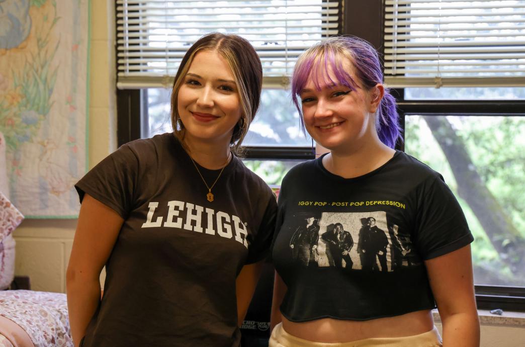 Two students stand together in their new dorm room