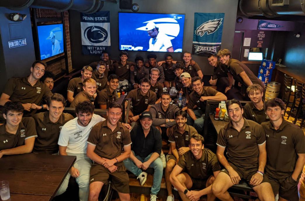 Evan Stein poses with the 2023 Lehigh soccer team at Olde City Cheesesteaks and Brew
