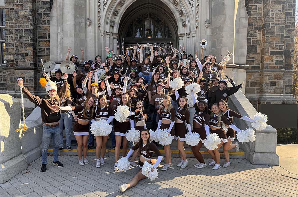 Lehigh University marching band and cheerleaders pose for a group photo on the entrance steps of Linderman Library.