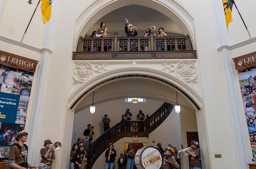 Lehigh University's marching band performs inside of the Alumni Memorial Building atrium and stairwell.