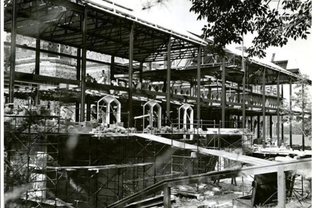 A 1955 black and white photo of the UC construction shows window frames and support beams, showcasing the multilevel project.