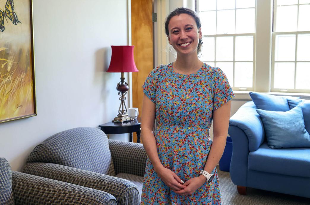 Brooke Kohler stands in an office filled with plush seating and a bright window behind her.