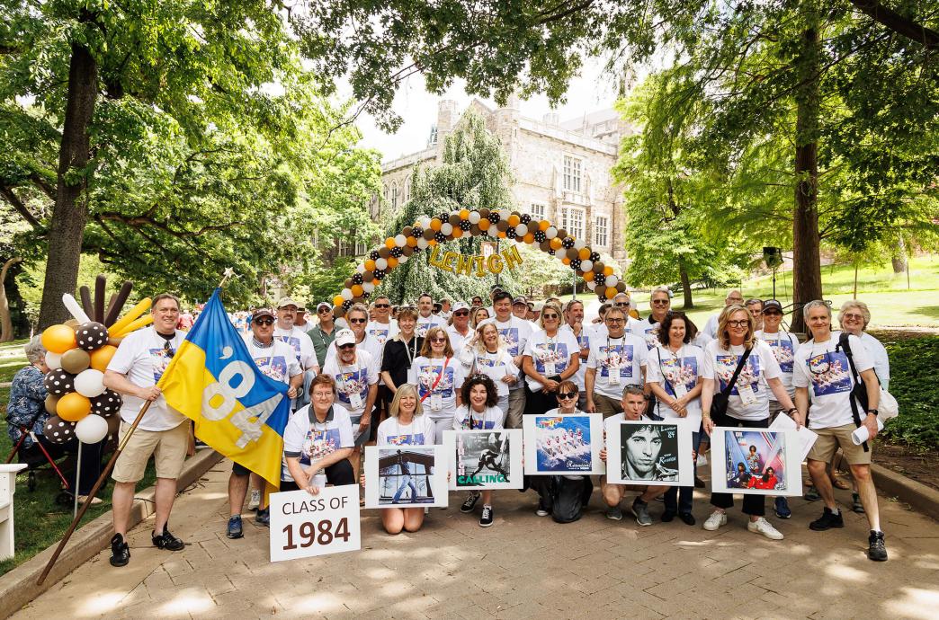 Class of 1984 holds photos of album covers from music during their time as students.