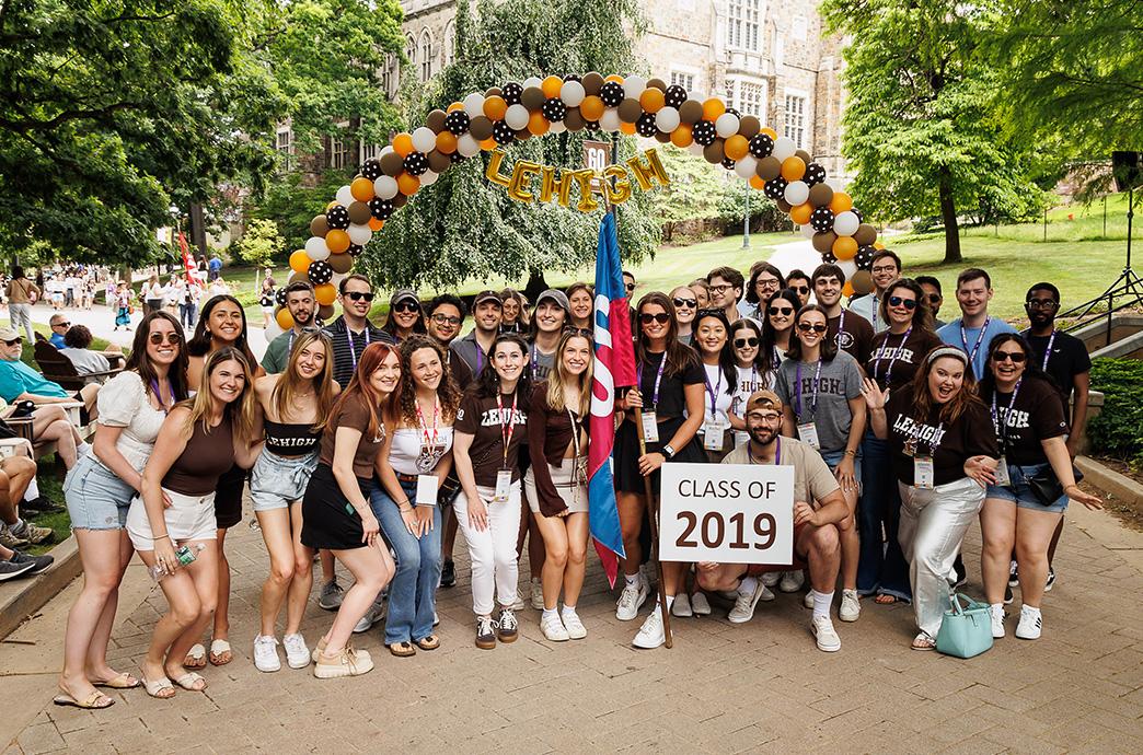 Members of the Class of 2019 stand below a balloon arch during the Reunion parade