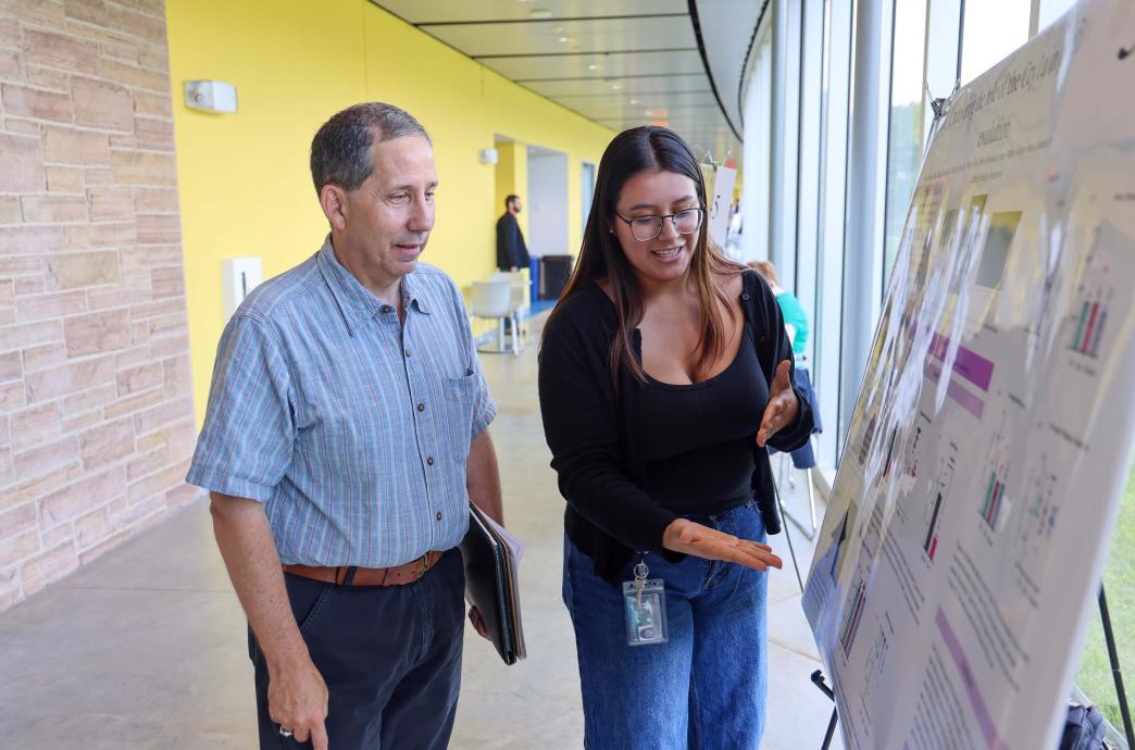 Martin Selzer ’83 stops to discuss “Uncovering the Role of the Cry1a in Cavefish Evolution” with the project’s student researcher.