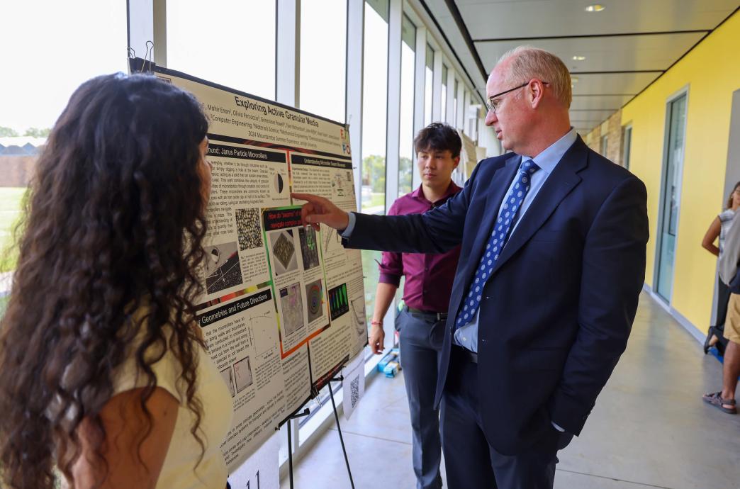 Provost Nathan Urban inquires about the data presented at the Research Expo.