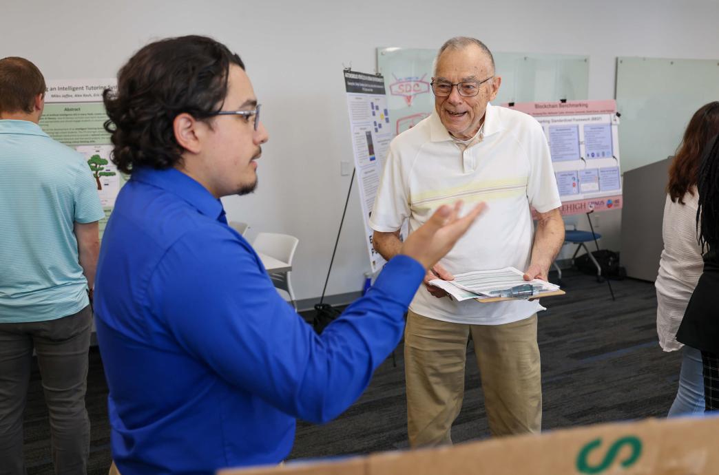 As an Expo judge, Norman Rumpf ’59 listens happily to each student presentation. 