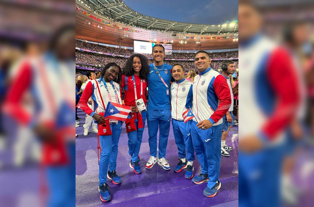 Darian Cruz stands alongside his fellow Puerto Rican olympians, wearing their countries colors inside an Olympic stadium