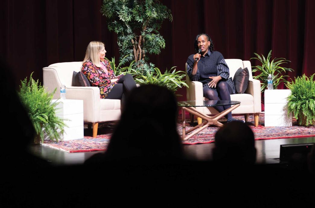 Jackie Joyner-Kersee sits on a white couch on stage for her panel discussion.