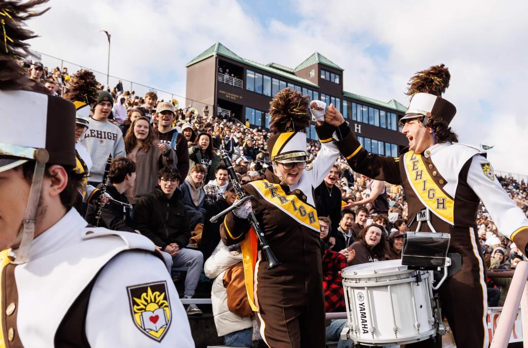 Members of the Lehigh Marching 97 in their uniforms, cheering.