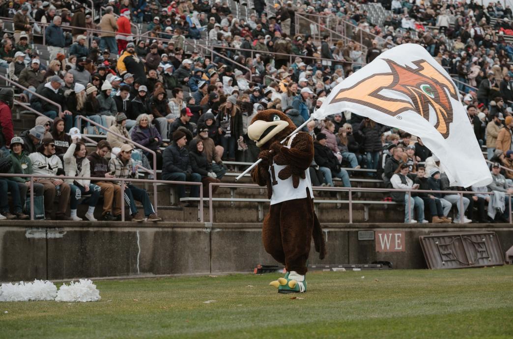 Clutch waving a white, L-Hawk flag in front of the bleachers at Goodman Stadium.