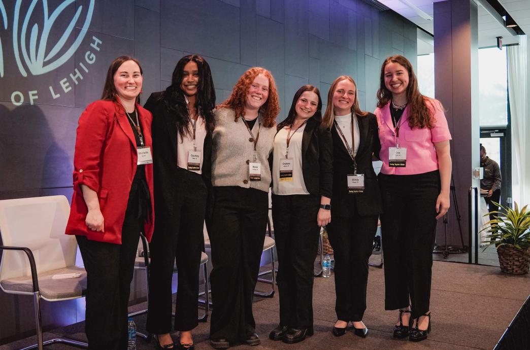 Five female students pose on stage with Michelle Spade joining them on their left.
