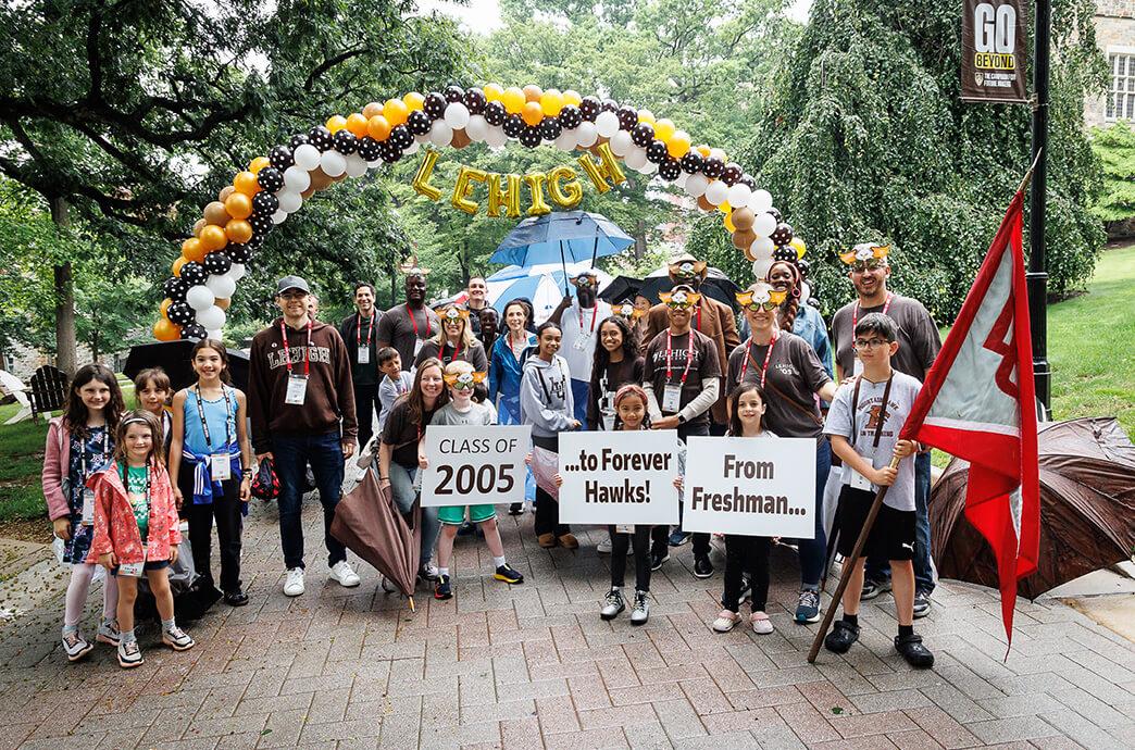 A diverse group of alumni from the Class of 2005 celebrates reunion under a balloon arch labeled "Lehigh." 