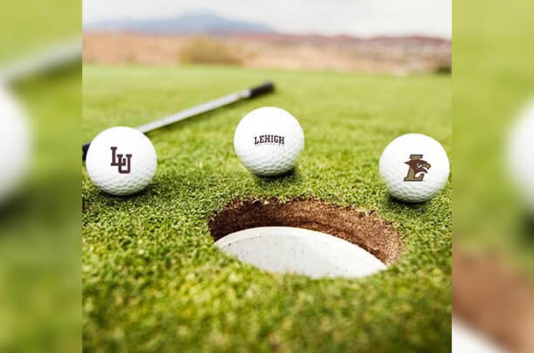 Three Lehigh-branded gold balls resting around the cup