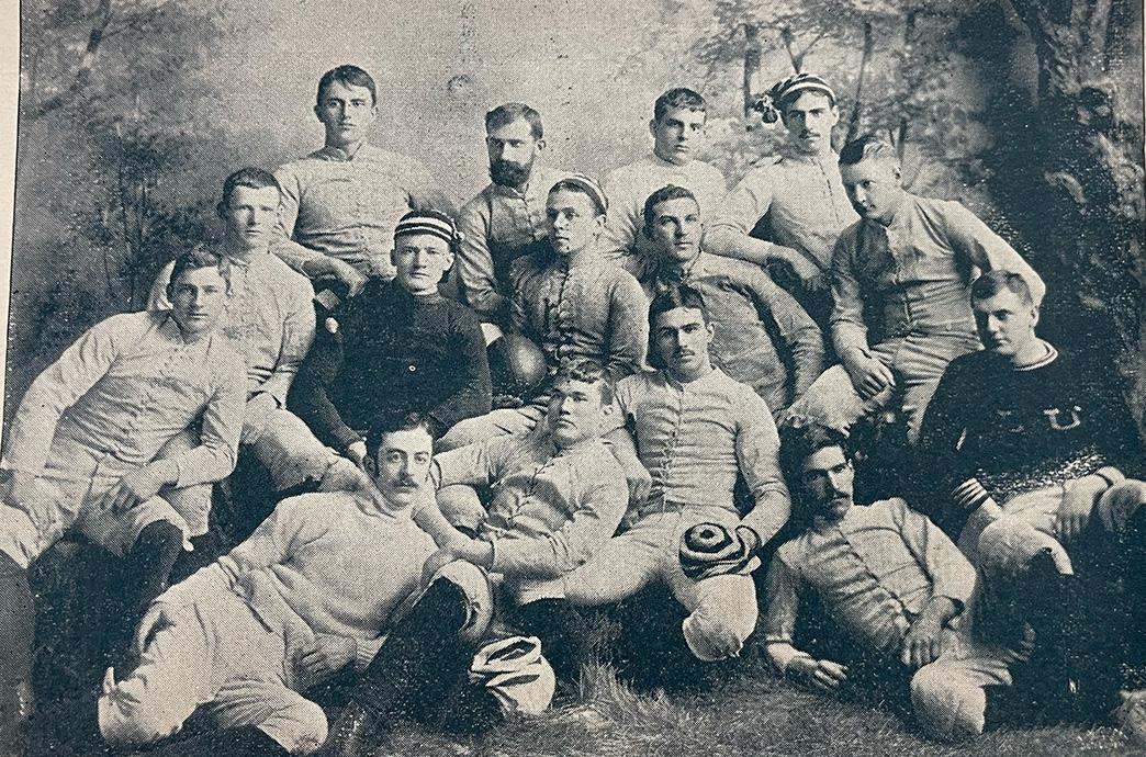 Players pose in their uniforms. Some stand and some lay around.