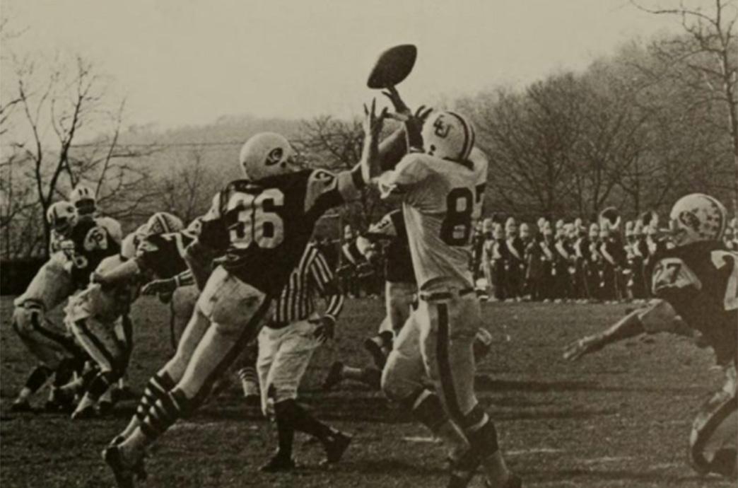 A receiver extends his hands to catch a pass.