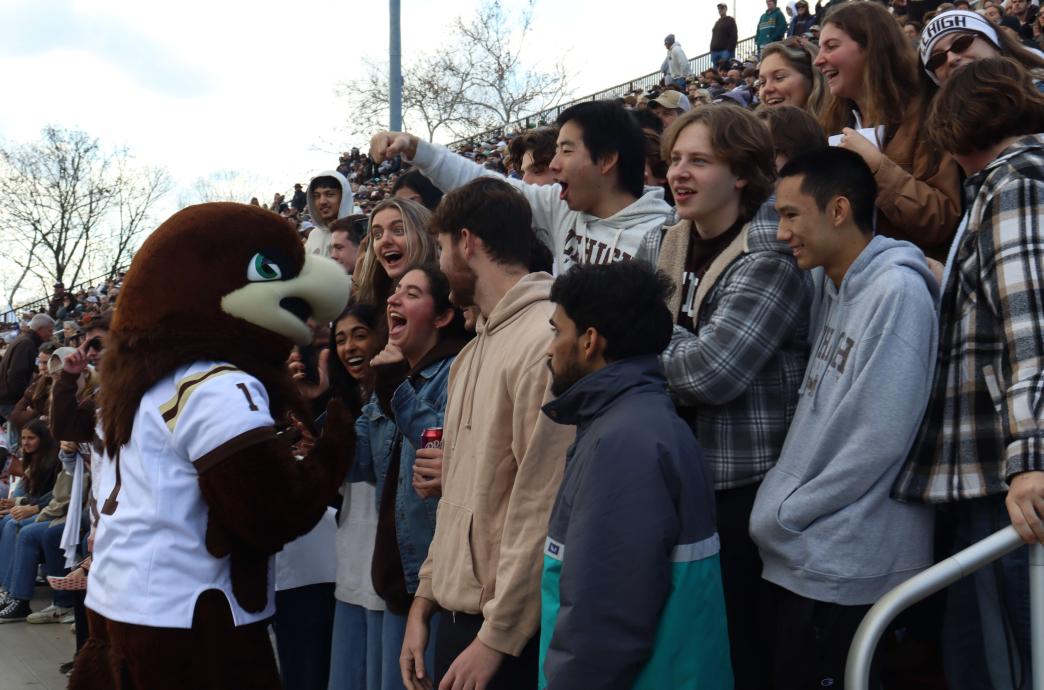 Clutch stands facing an excited group of young fans that smile and laugh; several of the fans wear Lehigh sweatshirts. 