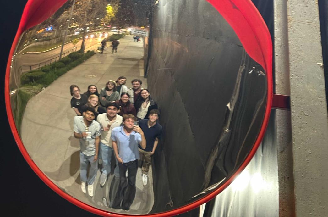A group of students smile at their reflections while walking through Chile.