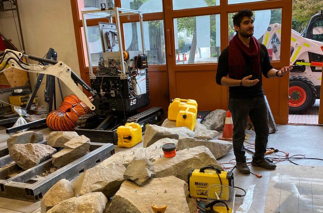 A Ph.D. student at the University of Chile’s Department of Mining Engineering lectures alongside rocks and machinery.