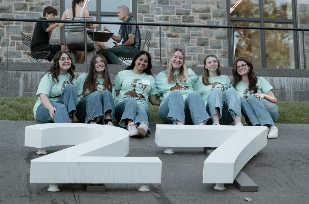 Students wear mint shirts that read 'lowkey Asa vibes' while sitting above the class of 27 numbers at the Clayton UC.