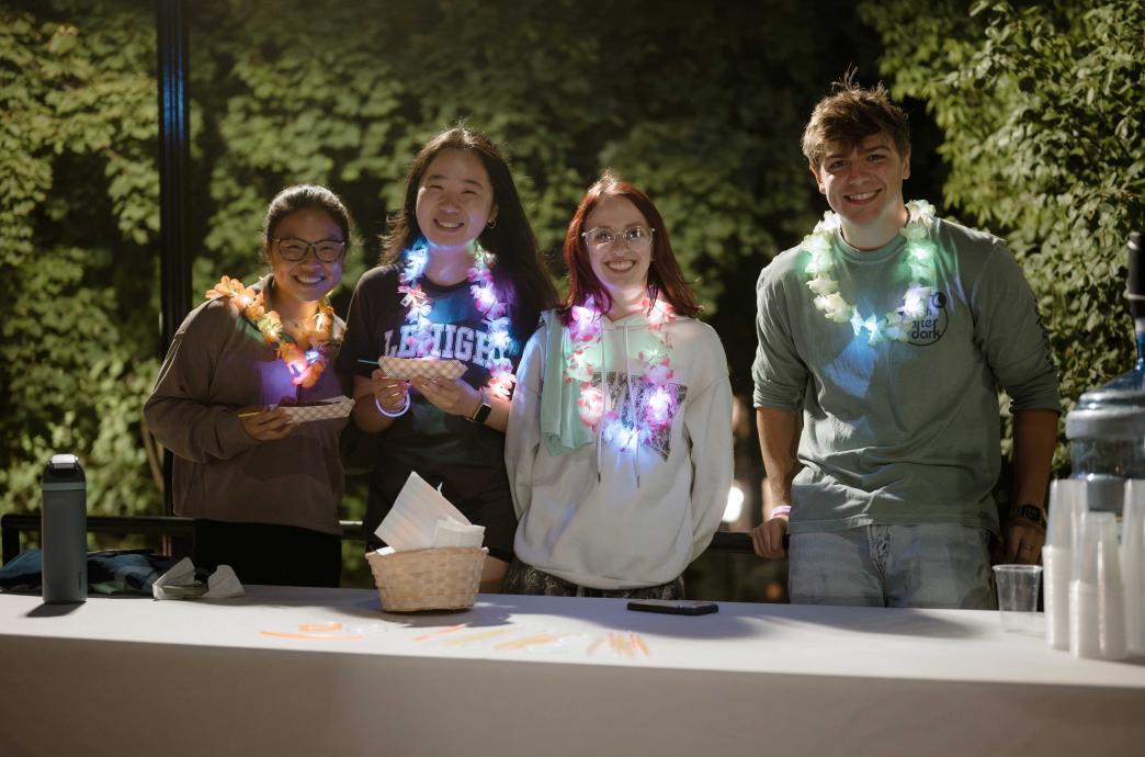A group of students attend Lehigh After Dark sporting Lehigh merch and light-up leis. 