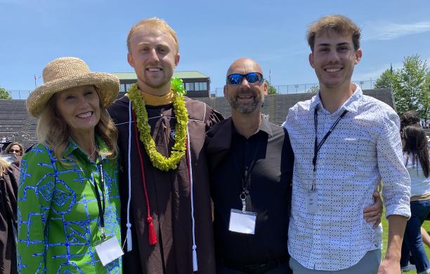 Karen and Garrett Baum taking a family photo with their children at their son's graduation