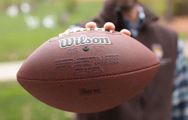 The associate professor of mechanical engineering holding a football