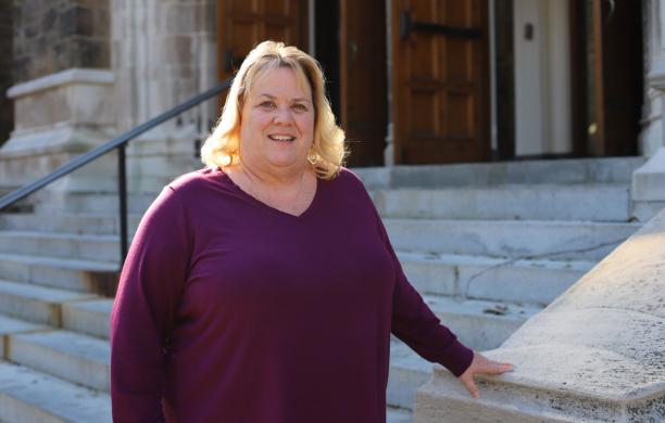 Mary Fronheiser standing on the steps of Alumni Memorial