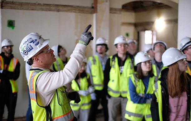 Construction leader points out work to students