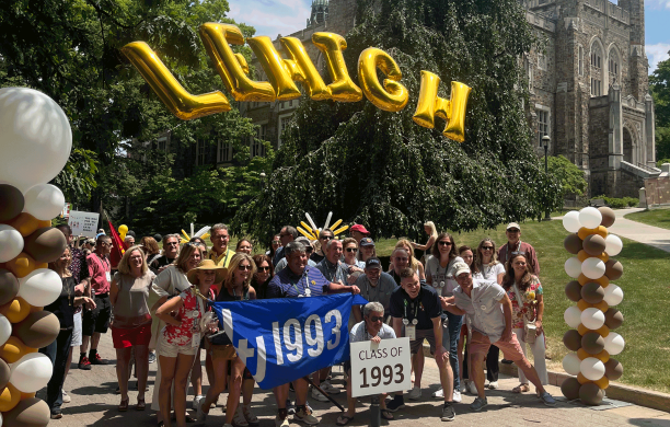 Lehigh alumni from the Class of 1993 pose for a photo on Lehigh University campus under a balloon arch that spells out Lehigh.
