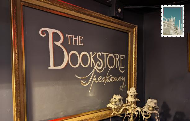"The Bookstore Speakeasy" written on a chalkboard sign in the entry of the restaurant