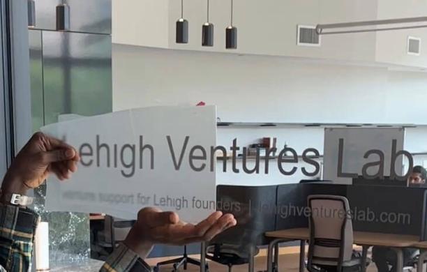 Lehigh's Ventures Lab sign being applied to glass by Dulra Amolegbe ’26