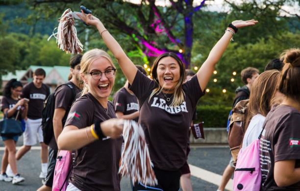 Two female students wearing brown Lehigh t-shirts while celebrating at the Rally 