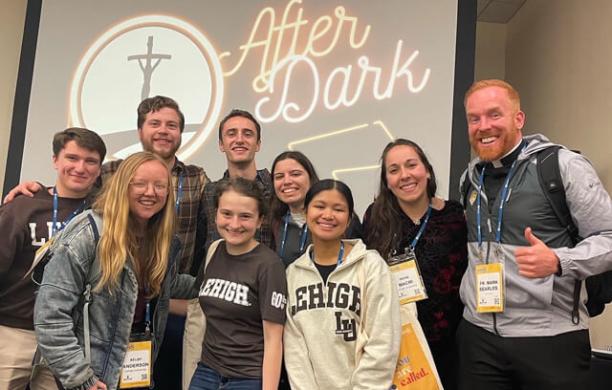 Father Mark Searles with Lehigh students