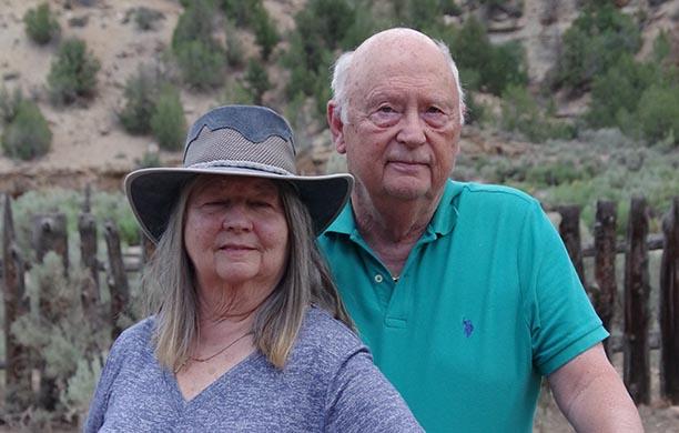 Barry and Connie Strohm stand beside each other in the scraggy Utah landscape
