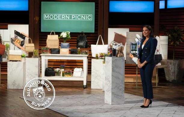 Ali Kaminetsky stands on the Shark Tank stage displaying her modern picnic products