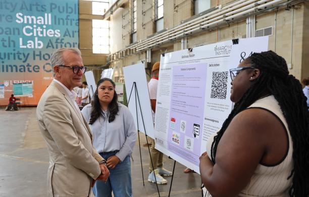 Ray Glemser listens as students present their research at the 2024 Reseach Expo