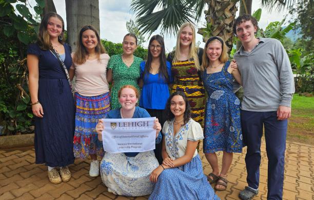 In front of palm trees, students pose and smile while holding a Lehigh University sign that reads "Iacocca Internship Program."