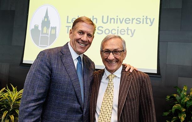 Kevin Clayton ’84 ’13P and Mike Caruso ’67 stand in Wood Dining Room.