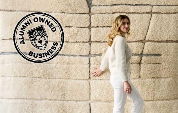 Erin Talgo standing before a handmade lambswool rug