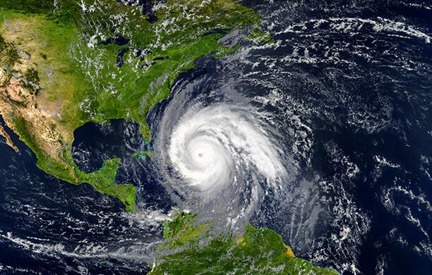 Hurricane clouds swirling over a satellite image the Florida coast and Atlantic Ocean.