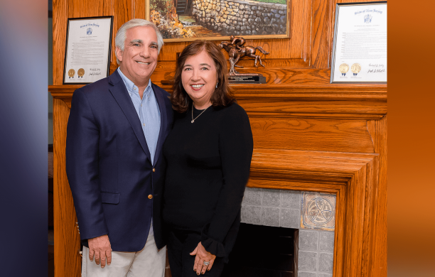 James and Sharon Maida standing together in front of a fireplace